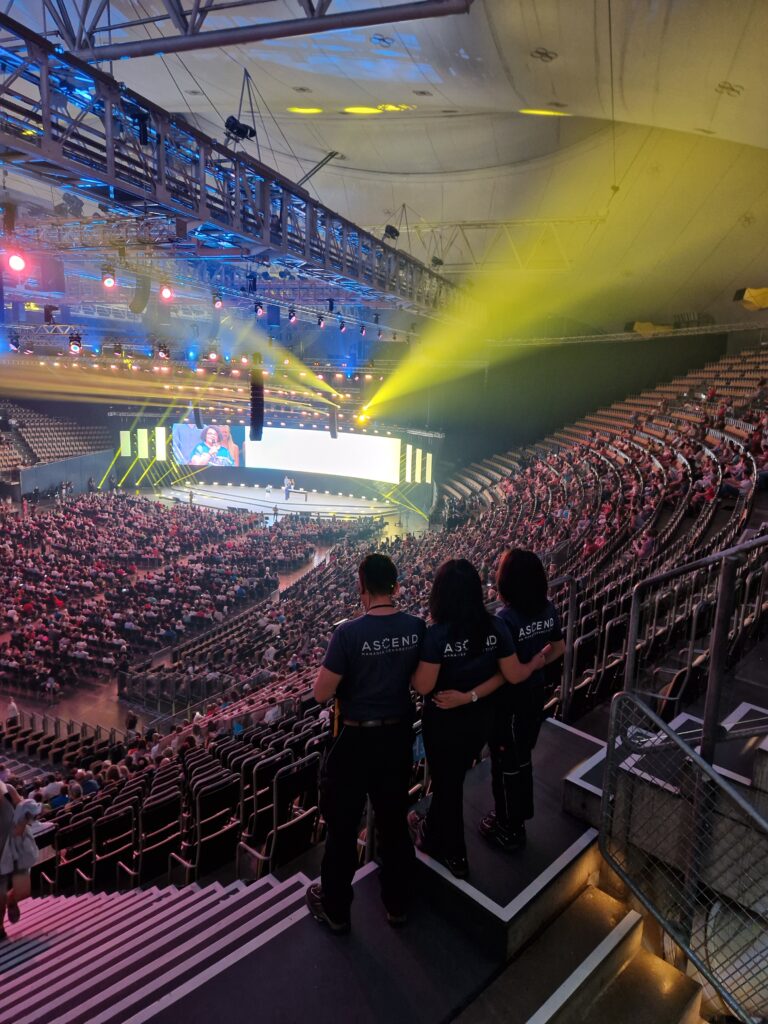 Pubblico all'evento in un'arena illuminata.