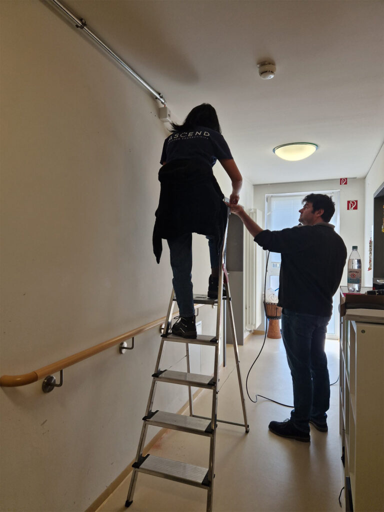 Un uomo sostiene una donna su una scala durante i lavori di installazione.